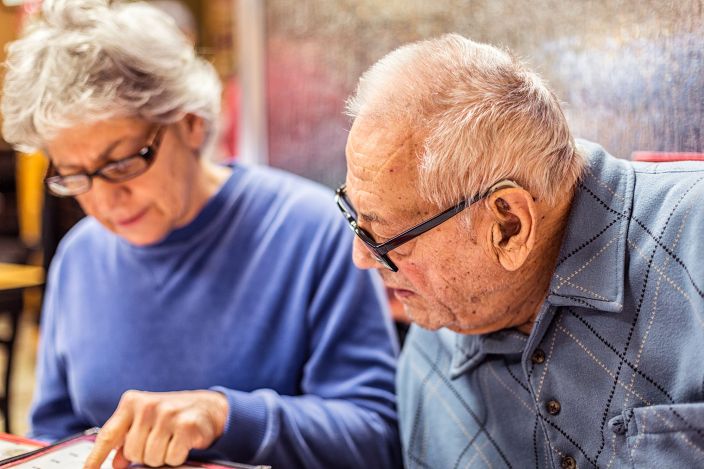 Elderly couple reading a menu